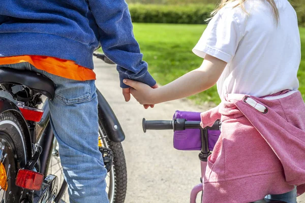 Chlapec a dívka drží za ruce na jejich jízdní kola — Stock fotografie