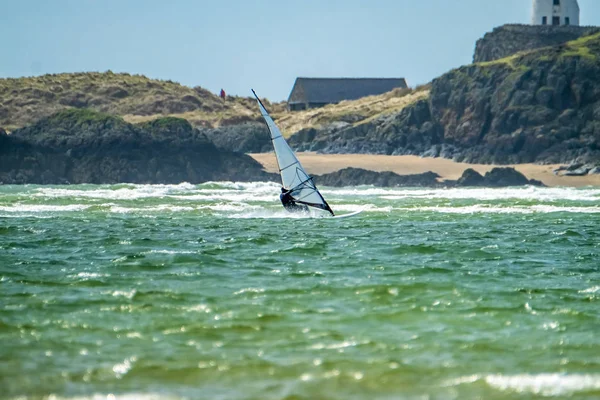 Вітер серфер користується пляжу в велика Уоррен з острова Llanddwyn на задньому плані, острів Англсі, Північного Уельсу, Великобританія — стокове фото