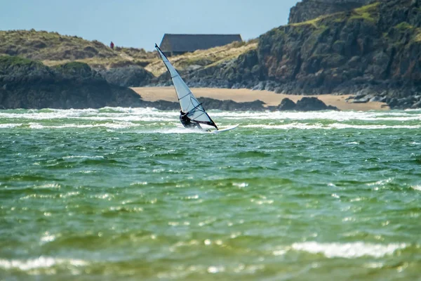 Вітер серфер користується пляжу в велика Уоррен з острова Llanddwyn на задньому плані, острів Англсі, Північного Уельсу, Великобританія — стокове фото