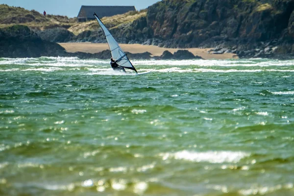 Széllovas élvezi a tengerparton Newborough Warren, a sziget Llanddwyn a háttérben, Isle of Anglesey, North Wales, Egyesült Királyság — Stock Fotó