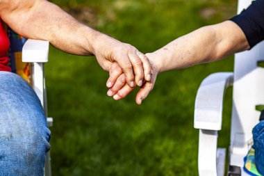 Üst düzey çift birlikte bahçede otururken elele