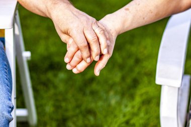 Üst düzey çift birlikte bahçede otururken elele