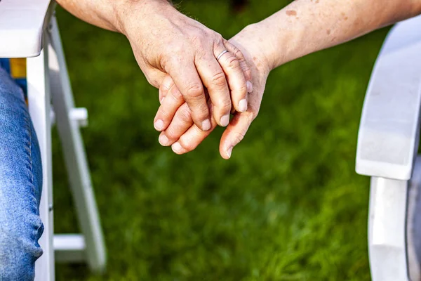 Üst düzey çift birlikte bahçede otururken elele