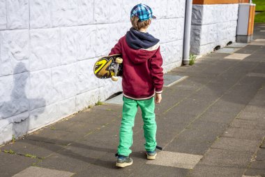 Genç longboard ile beyaz duvar boyunca yürüyüş