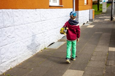 Genç longboard ile beyaz duvar boyunca yürüyüş