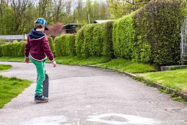 Malý městský chlapec cvičí s skateboard. — Stock fotografie