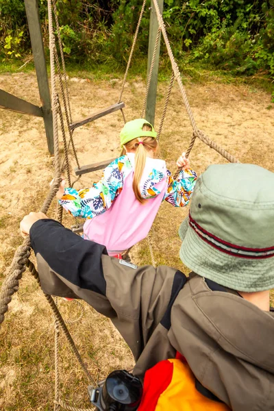 Liten pojke och flicka klättrar på nätet leddar i äventyrspark — Stockfoto