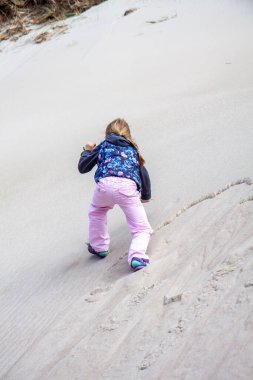 Küçük kız yazın tepeye tırmanıyor.
