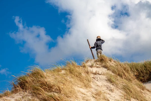 모래 언덕 위에서 있는 어린 소년 — 스톡 사진