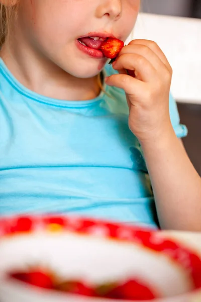 Крупним планом маленька дівчинка їсть свіжу полуницю — стокове фото