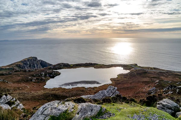 Solnedgang over sjøen ved Slieve League Cliffs som er blant de høyeste klippene i Europa som stiger over Atlanterhavet - County Donegal, Irland . – stockfoto