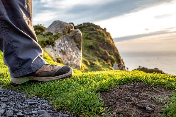 Stivali da trekking piedi sul bordo roccioso della scogliera — Foto Stock