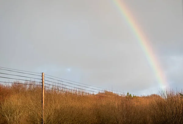 Linha fixa de energia na Irlanda com arco-íris no fundo — Fotografia de Stock