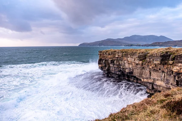 Riesige Wellen brechen an muckross head - eine kleine Halbinsel westlich von killybegs, county donegal, irland. Die Felsen der Klippen sind berühmt für ihr Klettern — Stockfoto