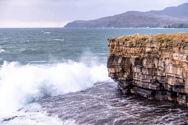 Hatalmas hullámok törnek ki Muckross Headnél - egy kis félsziget Killybegstől nyugatra, Donegal megyében, Írországban. A sziklák híresek a mászásról. — Stock Fotó
