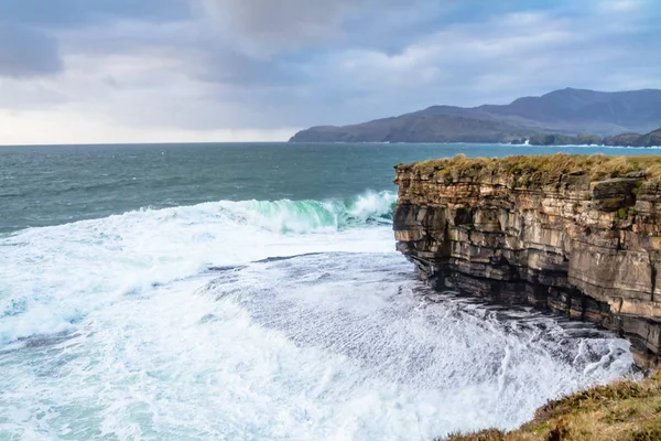 Riesige Wellen brechen an muckross head - eine kleine Halbinsel westlich von killybegs, county donegal, irland. Die Felsen der Klippen sind berühmt für ihr Klettern — Stockfoto