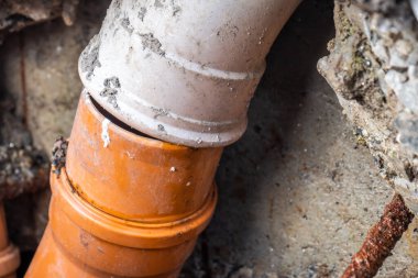 Broken pipes due to subsidence in the soil around the house clipart