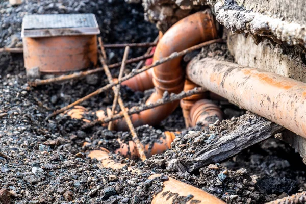 Разбитые трубы из-за оседания почвы вокруг дома — стоковое фото