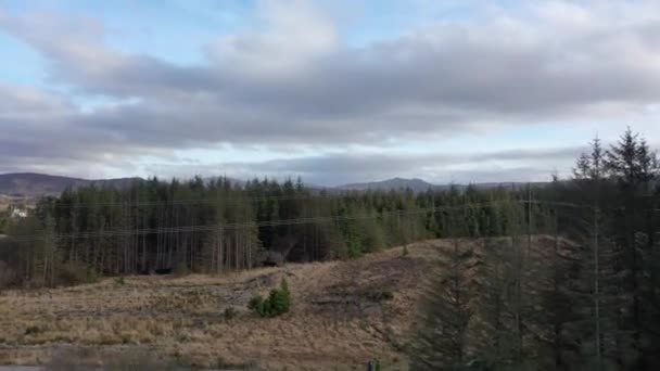 County Donegal, İrlanda 'daki Glenties kasabasının yakınındaki ormanın yanında uçuyor. — Stok video