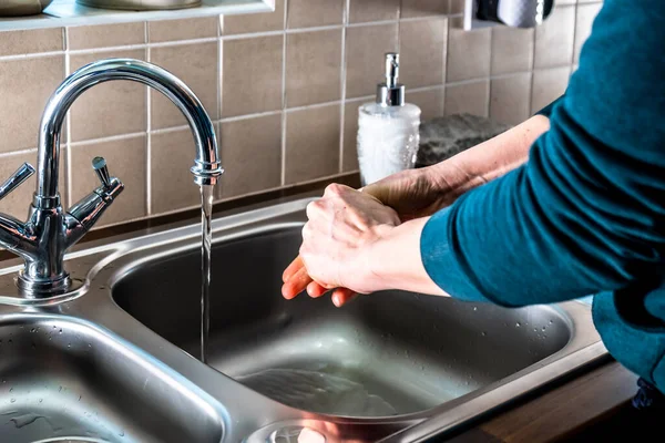 Proper washing of hands demonstrated at steel kitchen sink — Stock Photo, Image