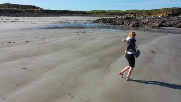 Όμορφη κυρία περπατά στη μοναχική αμμώδη παραλία — Αρχείο Βίντεο