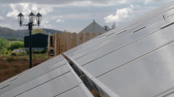 Fotovoltaik paneller, sıcak su için güneş panelleri olan evin yanındaki rafa monte edilmiş. — Stok video