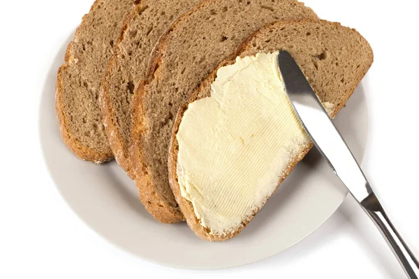 A knife spreading butter on bread — Stock Photo, Image