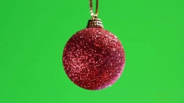 Yeşil ekran arkaplanı üzerinde kırmızı takı. Noel süslemesi