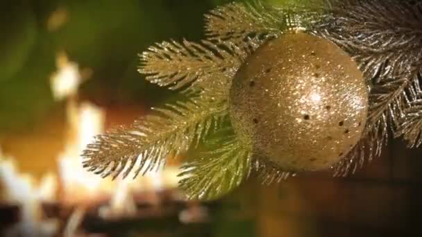 一棵金色的圣诞树 上面装饰着金光闪闪的金银财宝 映衬着燃烧的壁炉 — 图库视频影像