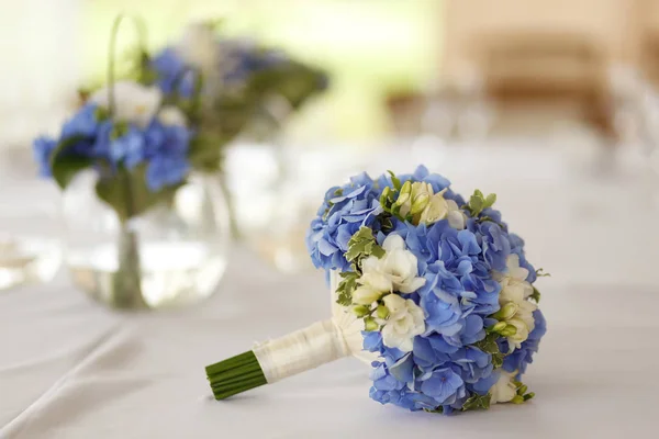 Beautiful wedding bouquet with white and blue flowers on table — Stock Photo, Image