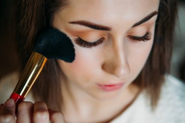 Güzel model makyaj sanatçısı tarafından uygulanan toz sahip