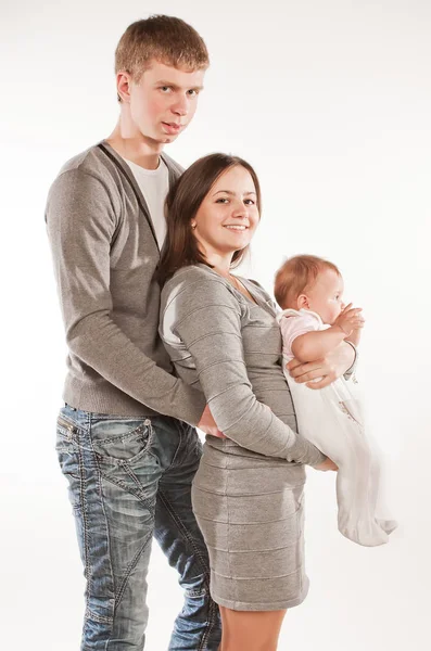 Glückliche Familie mit Kind posiert auf weißem Hintergrund — Stockfoto