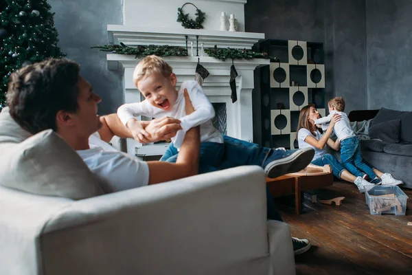 Cute parents play with their sons on the floor together indoor — Stock Photo, Image