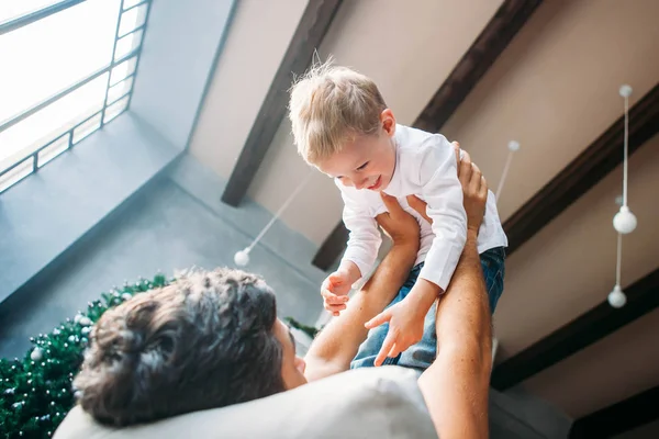 Father lying on the sofa and playing with his little son — Stock Photo, Image