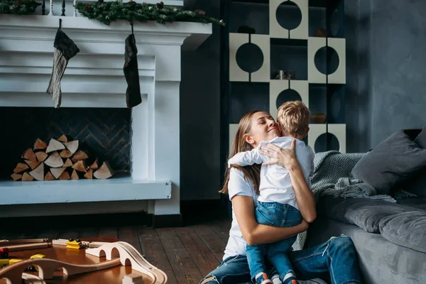 Cute mother and her son play on the floor together indoor — Stock Photo, Image