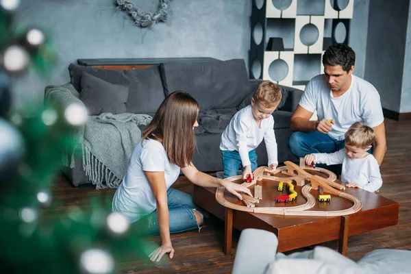 Happy family playing with toy railway road at home — Stock Photo, Image