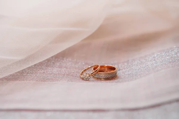 Esküvő gyűrű piros mezőben a textil háttér — Stock Fotó