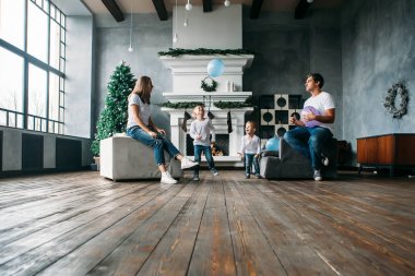 Babam ve annem kanepe oynamaya siting iki küçük oğlu balonlarla hava