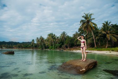 Plaj phu quoc üzerinde oturan genç beyaz kadın