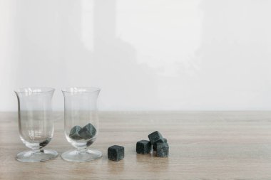 Viski ve makara tulup hafif ahşap arka plan üzerinde soğutma için taşlar