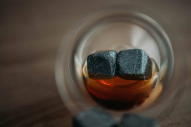 Viski ve makara tulup gark ahşap arka plan üzerinde soğutma için taşlar