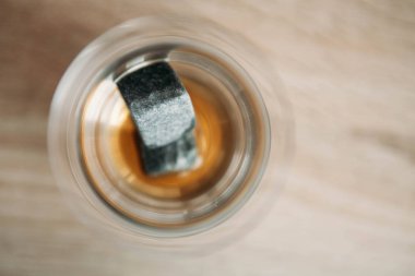 Viski ve makara tulup hafif ahşap arka plan üzerinde soğutma için taşlar