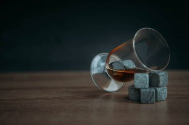 Viski ve makara tulup koyu ahşap arka plan üzerinde soğutma için taşlar