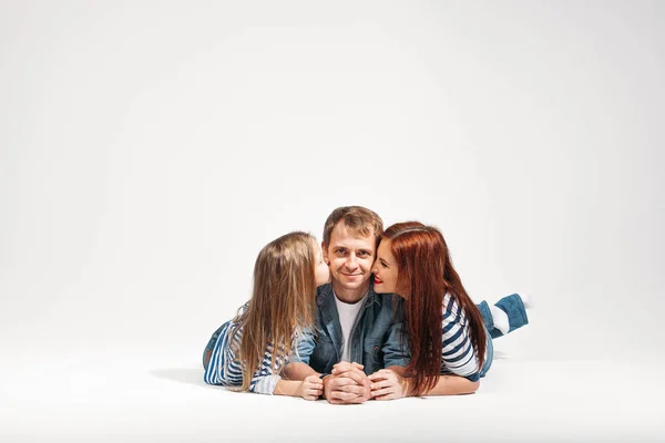 Feliz divertido familia besos papá retrato acostado en blanco fondo aislado — Foto de Stock