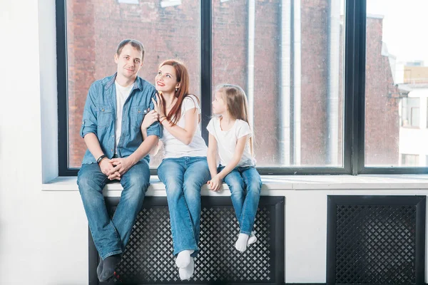 Pencere pervazına üzerinde oturma mutlu aile anne baba çocuk portre — Stok fotoğraf