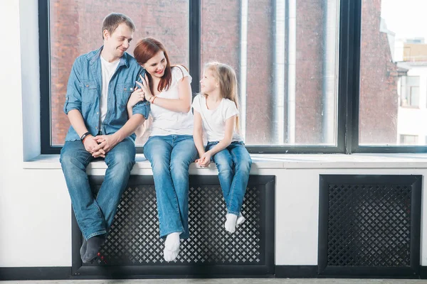 Feliz familia madre padre niño retrato sentado en ventana alféizar —  Fotos de Stock