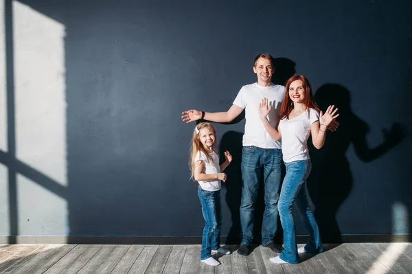 Glücklich Familienporträt stehend auf grauem Hintergrund Holzboden Zimmer Fenster sonniger Tag — Stockfoto