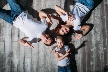 Mutlu aile portresi ahşap zemin oda pencere güneşli günde yalan