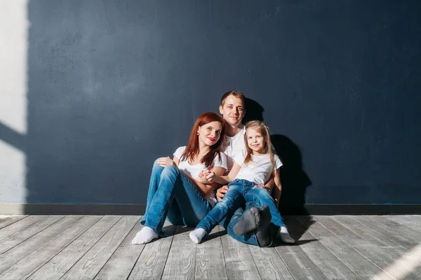 Mutlu aile portresi gri arka plan ahşap zemin oda pencere güneşli günde siting