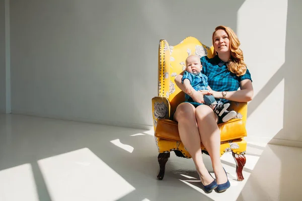 Aile portre fotoğraf bir anne ile küçük oğlu beyaz arka koltukta oturmak — Stok fotoğraf